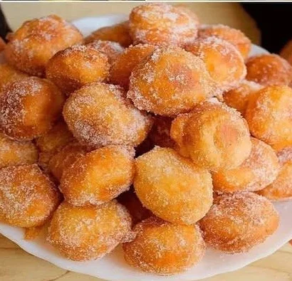 A plate of perfectly mini doughnuts topped with colorful sprinkles.