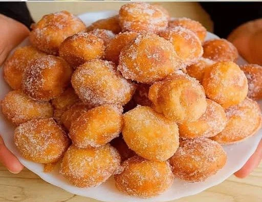A plate of perfectly mini doughnuts topped with colorful sprinkles.