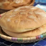 Homemade traditional Moroccan khobz bread, a round, crusty loaf made with flour and water.