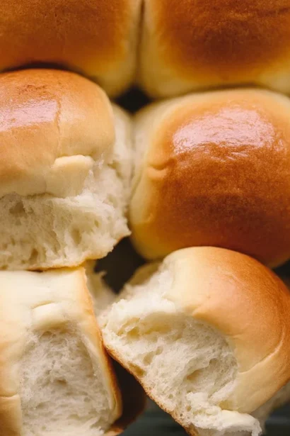 Freshly baked soft and fluffy dinner rolls on a wooden table
