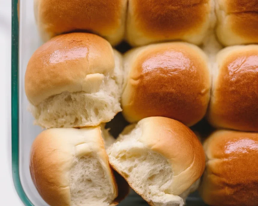 Freshly baked soft and fluffy dinner rolls on a wooden table