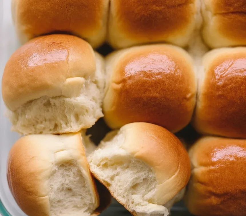Freshly baked soft and fluffy dinner rolls on a wooden table