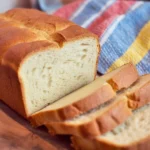 Easy homemade white bread loaves cooling on a rack, perfect for sandwiches.