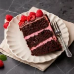 Delicious Chocolate Raspberry Cake topped with fresh raspberries and chocolate shavings