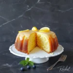 Delicious homemade lemon cake with frosting and lemon slices on top.