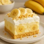 Homemade Banana Pudding Cake topped with whipped cream and banana slices.